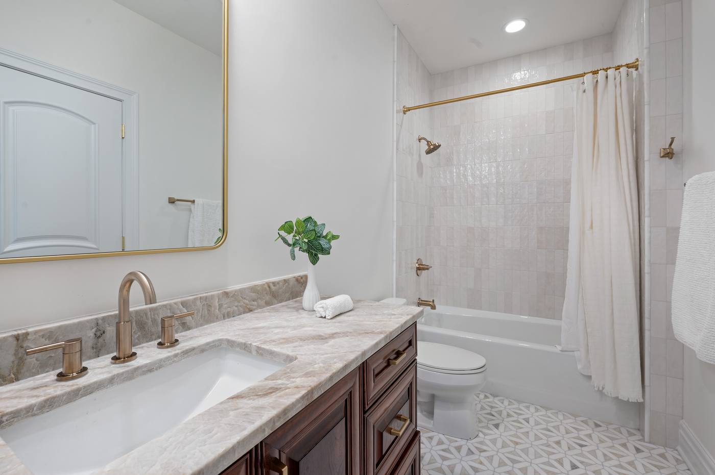 Bath with quartzite counter, tub and shower and a patterned marble floor