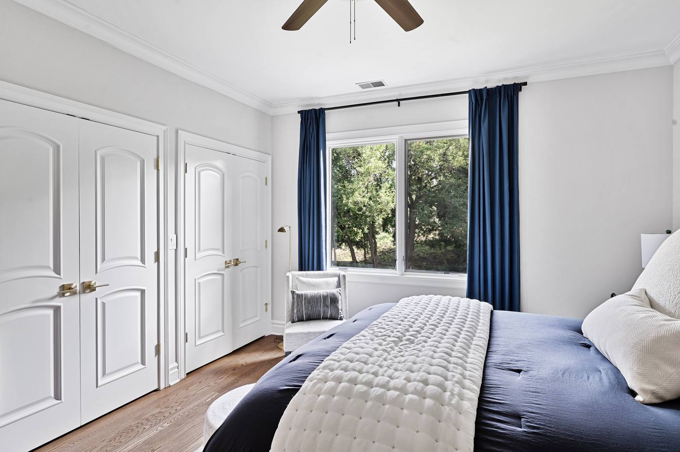 Bedroom with double closets and a window into the tree line