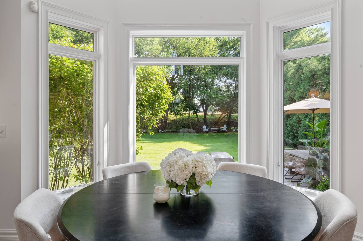 Breakfast room bay looking out to the lawn, patio and the tree line beyond