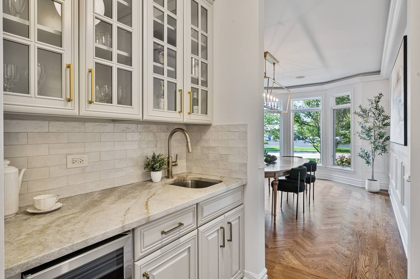 Butler's pantry with wet bar, beverage refrigerator and glass-front cabinetry