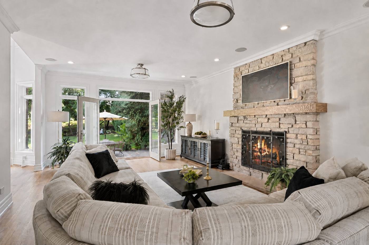 Family room with floor-to-ceiling stone fireplace and a wall of windows to the rear yard