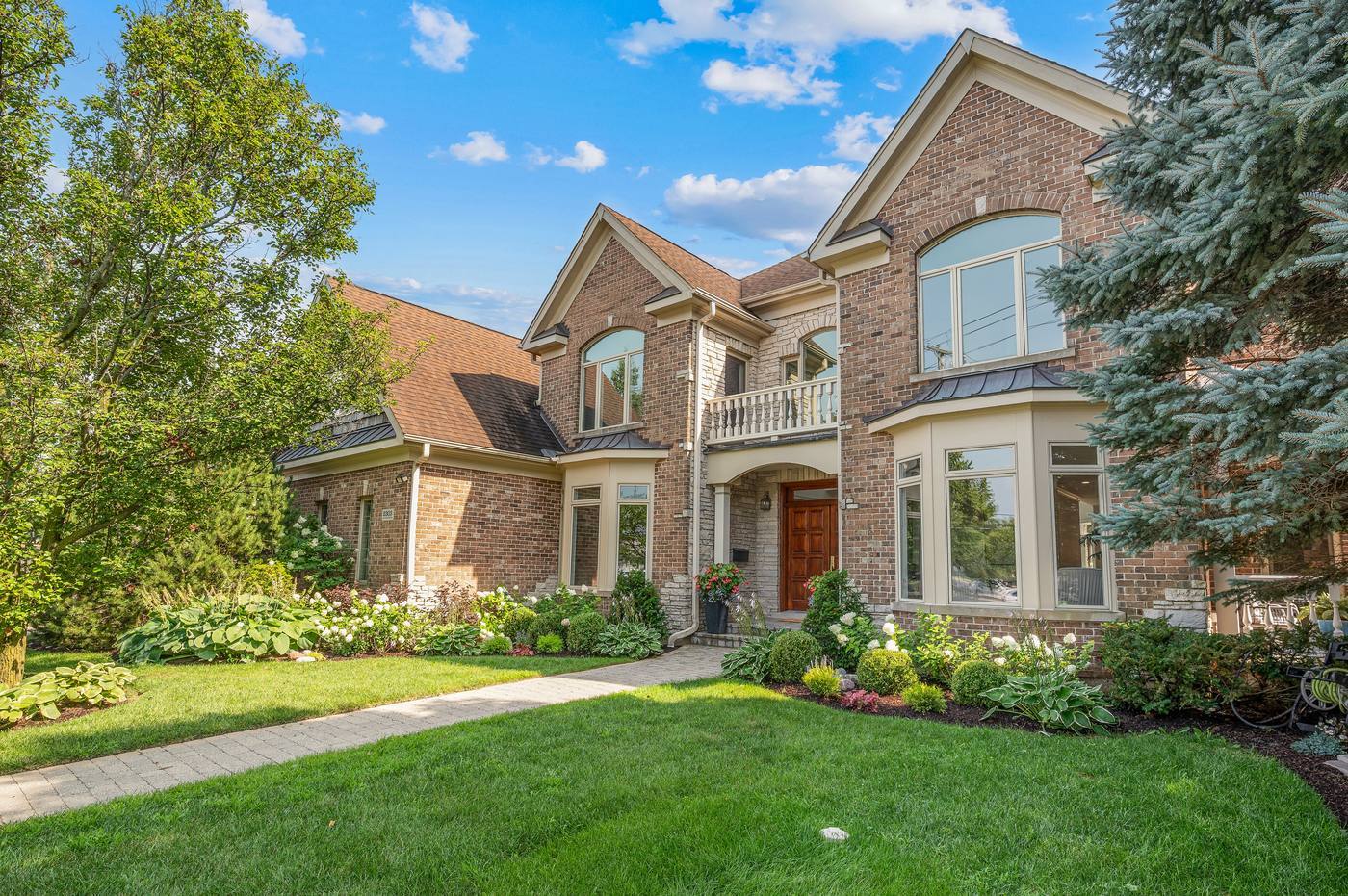 Front exterior of 2303 Old Glenview Road, Wilmette — brick and limestone with gabled rooflines and arched windows