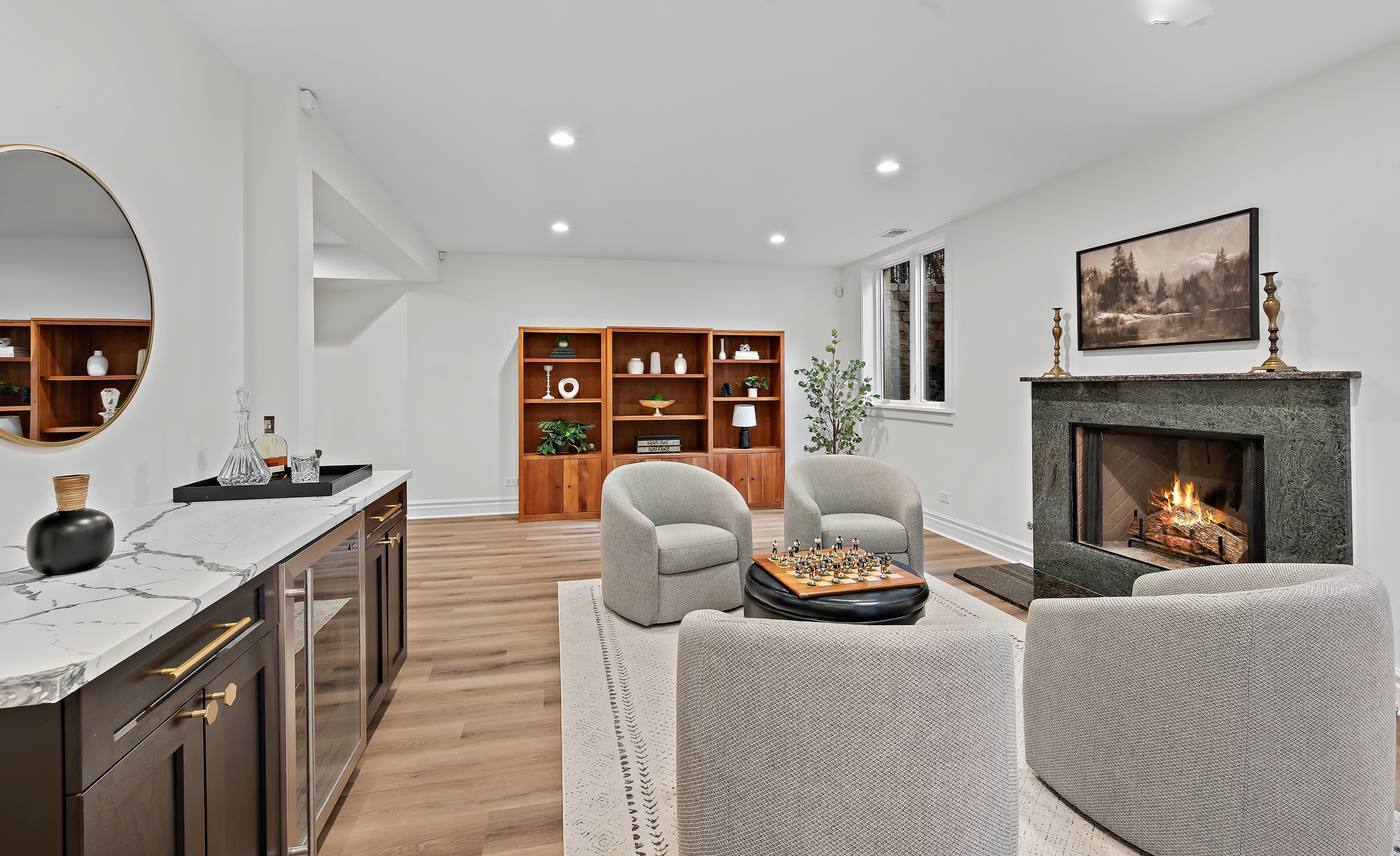 Lower level — bar and wine storage at one end, the fireplace seating area at the other