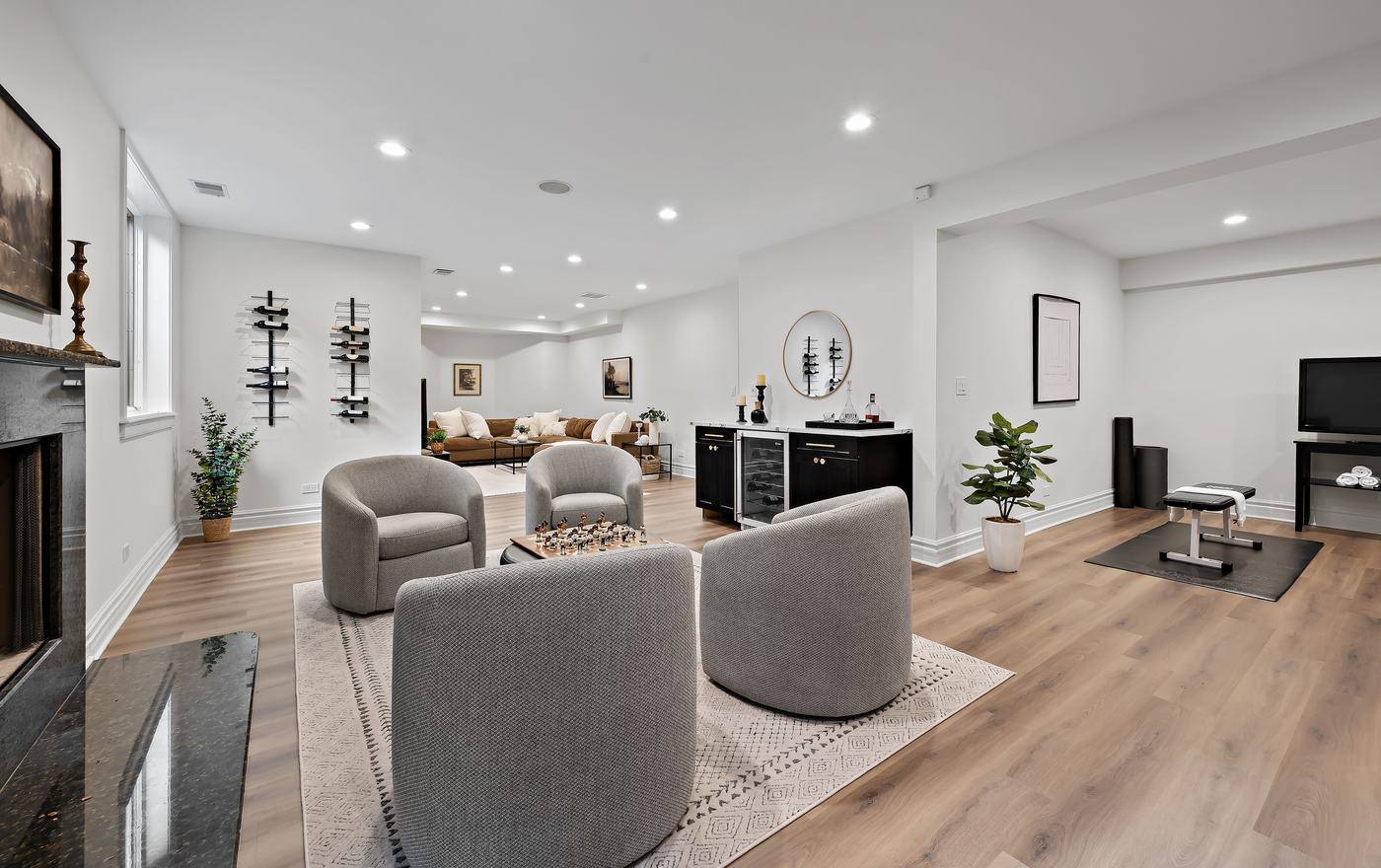 Lower level with lounge seating, bar, wine storage and fitness area
