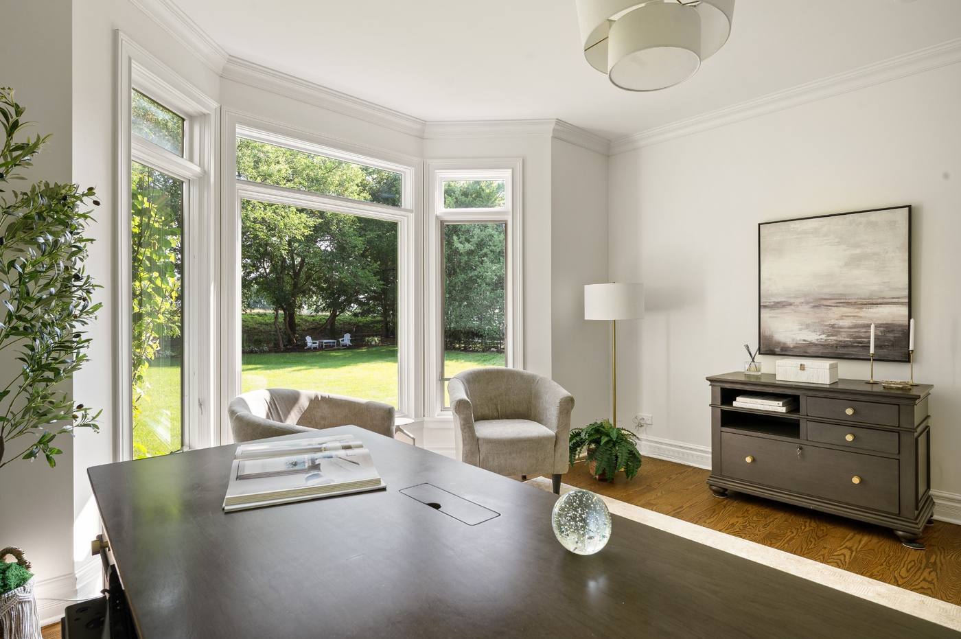 Main-level office in the turret bay, windows on three sides overlooking the rear lawn