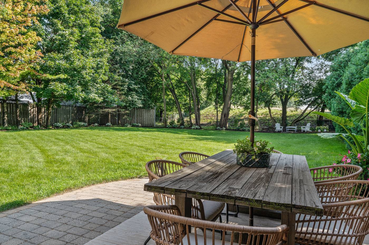 Paver patio and dining terrace looking across the lawn to the rear boundary