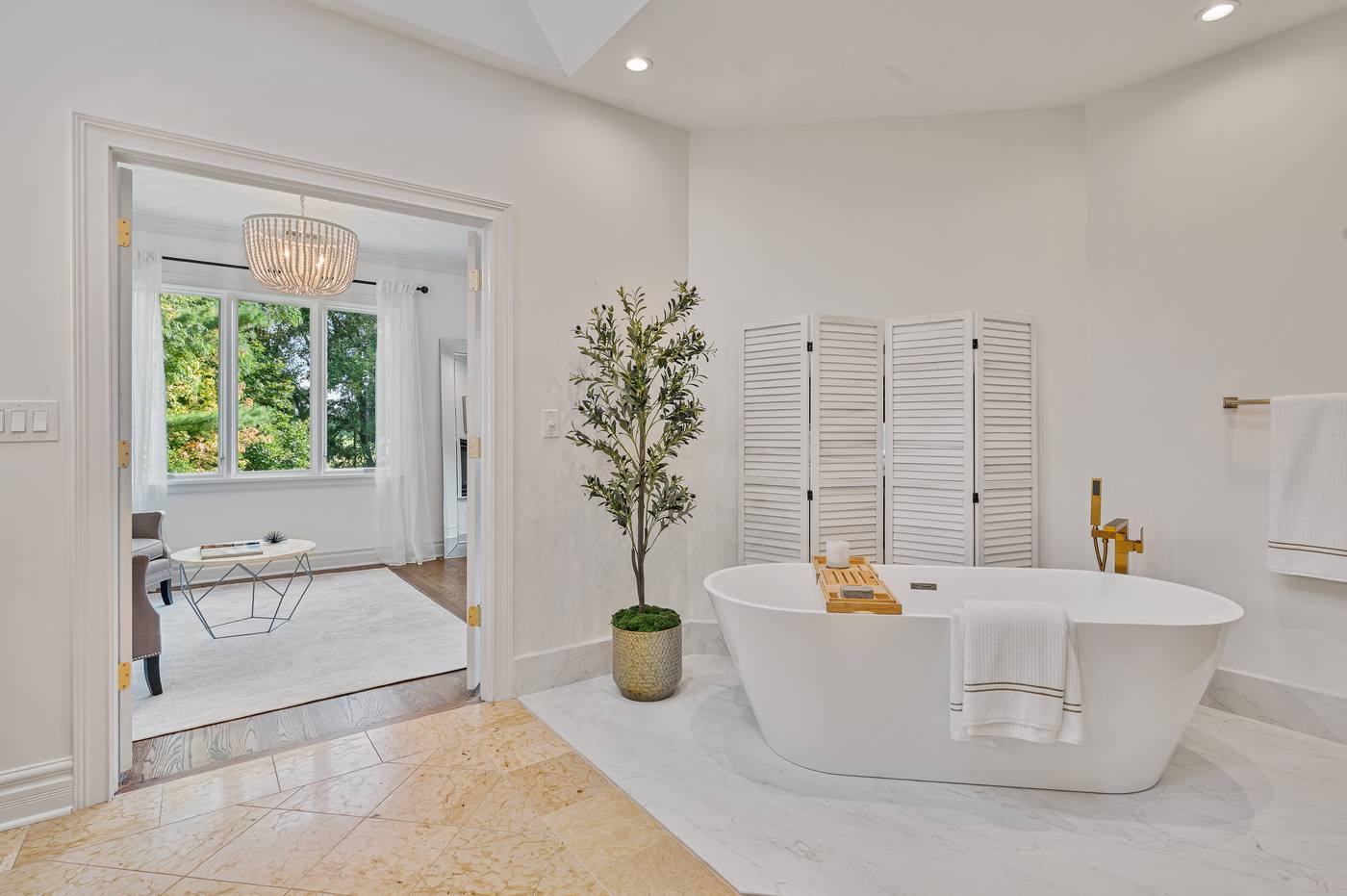 Primary bath with freestanding soaking tub, open to the sitting room beyond