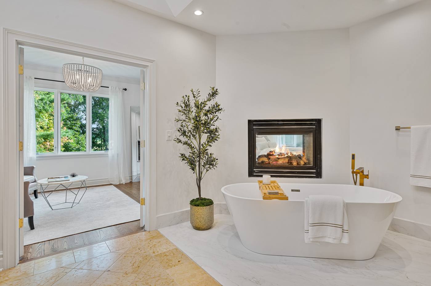 Primary bath tub set against the two-sided fireplace shared with the bedroom