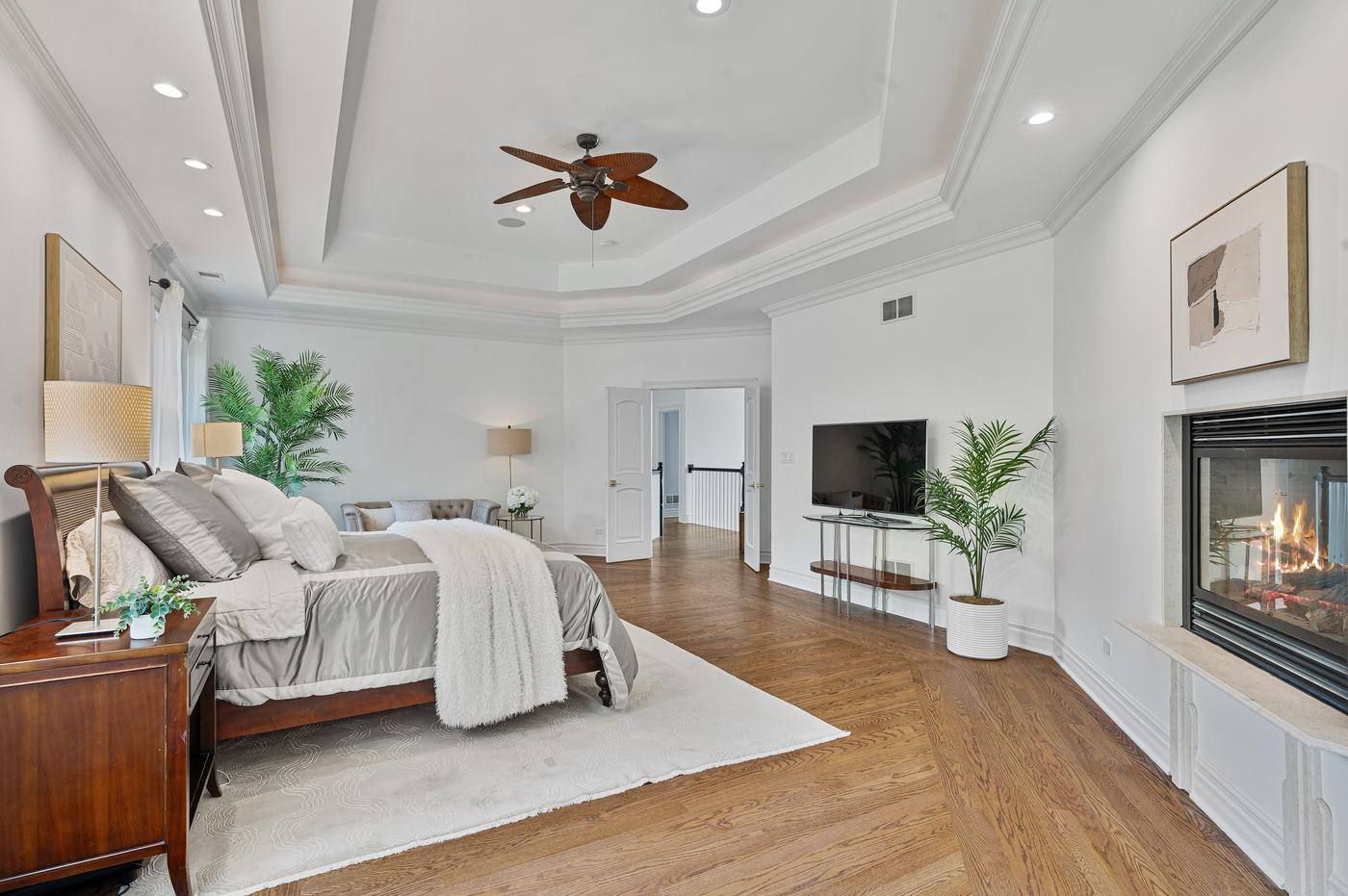Primary bedroom showing the sitting area, fireplace and tray ceiling