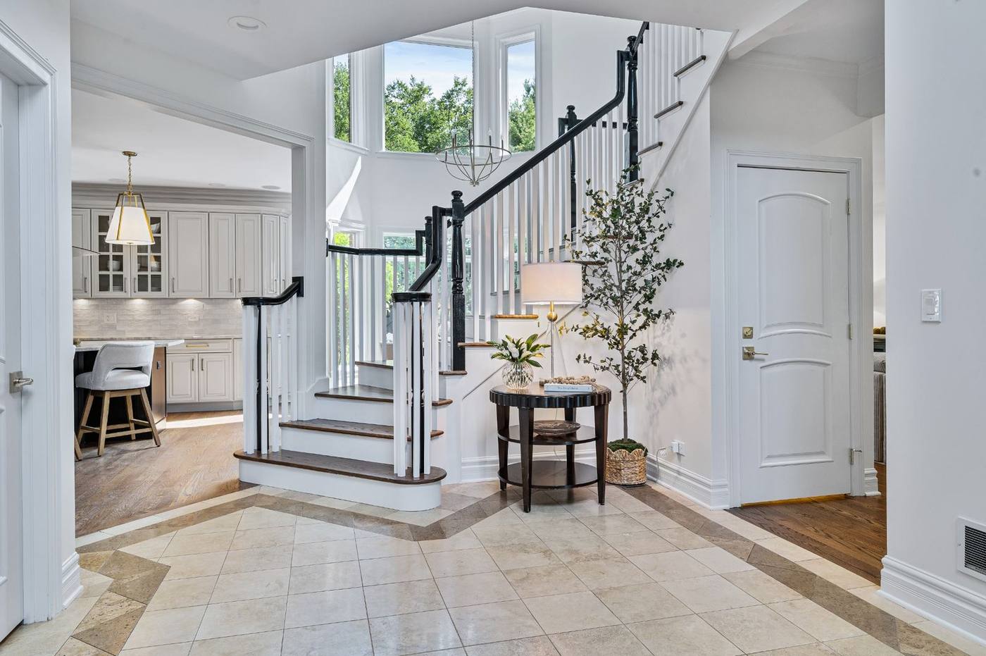 Two-storey foyer and staircase looking through to the kitchen